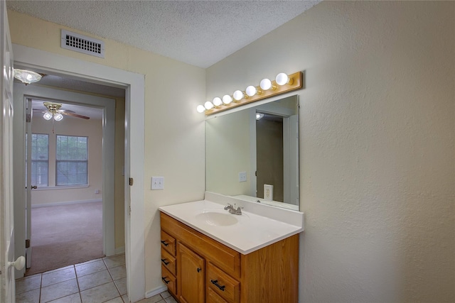 bathroom featuring tile patterned flooring, vanity, ceiling fan, and a textured ceiling