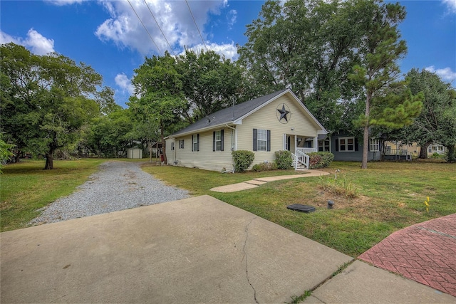 view of front of property with a storage shed and a front yard