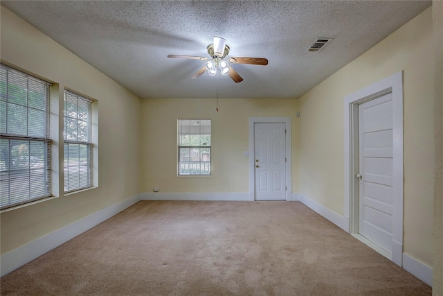 carpeted empty room featuring ceiling fan and a textured ceiling