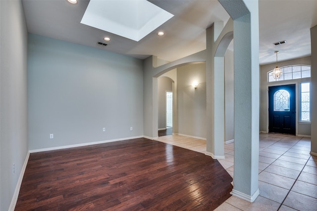 foyer with a skylight and light hardwood / wood-style flooring