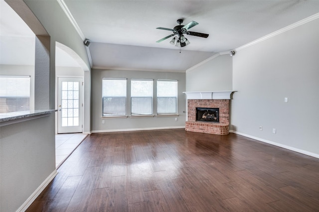 unfurnished living room featuring vaulted ceiling, hardwood / wood-style floors, a fireplace, ornamental molding, and ceiling fan