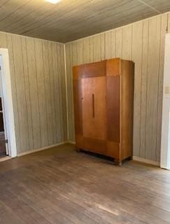 spare room with wooden ceiling, hardwood / wood-style floors, and wood walls