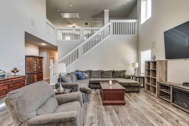 living room featuring a high ceiling, hardwood / wood-style flooring, and a wealth of natural light