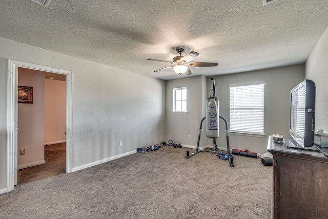 workout room with light carpet, a textured ceiling, and ceiling fan