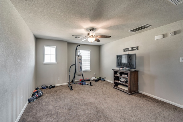 workout area featuring a textured ceiling, ceiling fan, and carpet