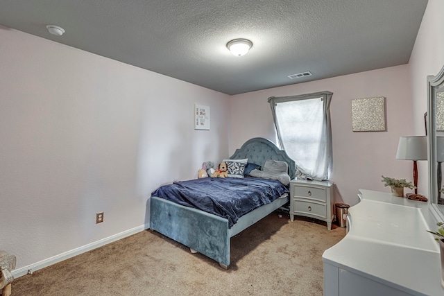 bedroom featuring light colored carpet and a textured ceiling