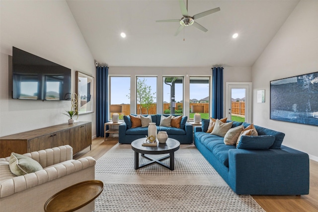 living room with vaulted ceiling, ceiling fan, and light hardwood / wood-style floors