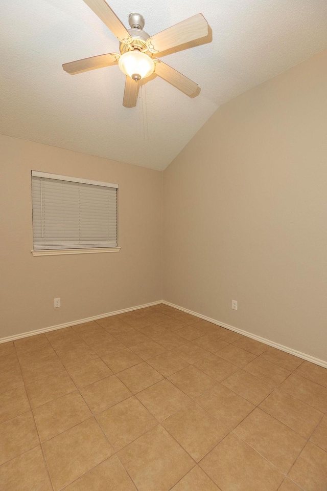 tiled spare room with ceiling fan and vaulted ceiling