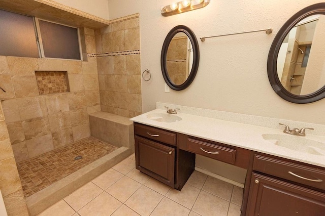 bathroom with vanity, a tile shower, and tile patterned floors