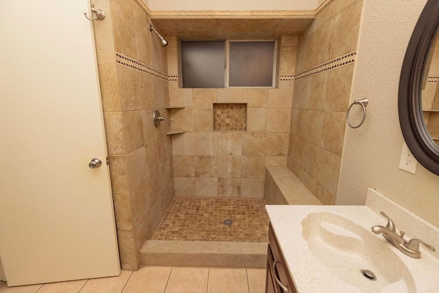 bathroom featuring vanity, tile patterned flooring, and tiled shower