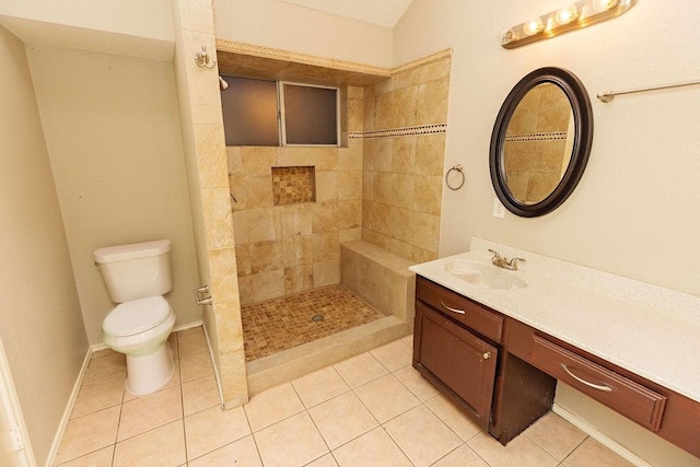 bathroom with vanity, toilet, tile patterned flooring, and a tile shower