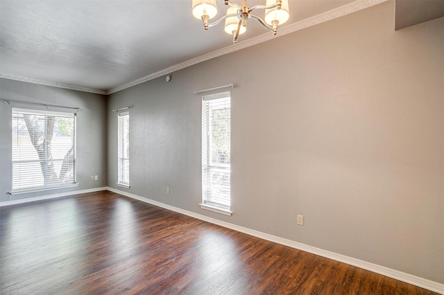 spare room with crown molding, dark hardwood / wood-style flooring, and a notable chandelier