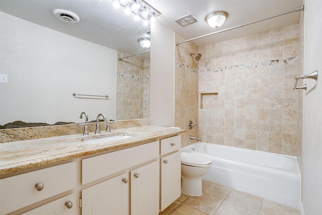 full bathroom featuring tile patterned floors, vanity, toilet, and tiled shower / bath combo