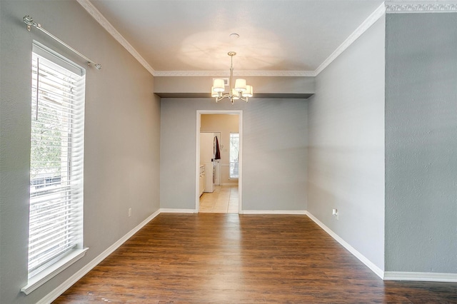 unfurnished room featuring wood-type flooring, ornamental molding, and a notable chandelier