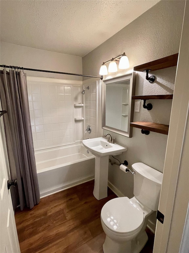 full bathroom featuring shower / tub combo with curtain, toilet, sink, a textured ceiling, and hardwood / wood-style flooring