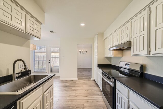 kitchen with stainless steel electric range oven, black dishwasher, sink, a notable chandelier, and light hardwood / wood-style flooring