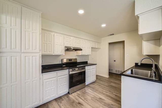 kitchen featuring electric stove, sink, light hardwood / wood-style flooring, and white cabinets