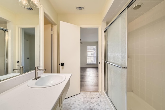 bathroom featuring walk in shower, vanity, and tile patterned flooring