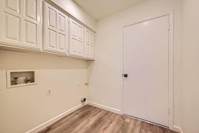 clothes washing area with cabinets, hookup for a washing machine, and light wood-type flooring