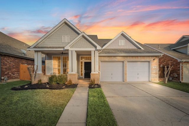 view of front of property featuring a garage, a yard, and covered porch