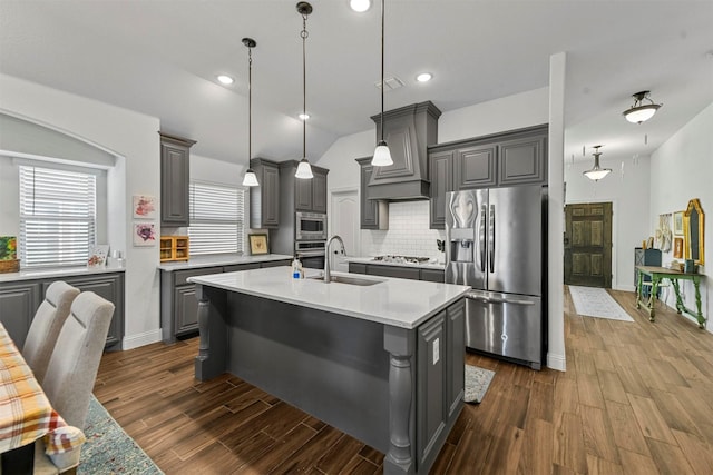 kitchen with stainless steel appliances, sink, gray cabinets, and a kitchen island with sink