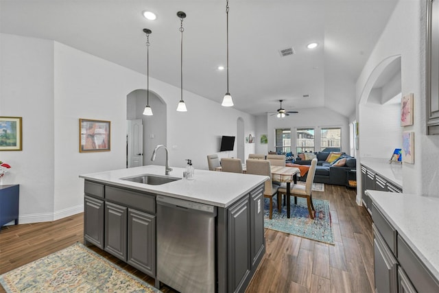 kitchen featuring sink, stainless steel dishwasher, gray cabinets, pendant lighting, and a kitchen island with sink