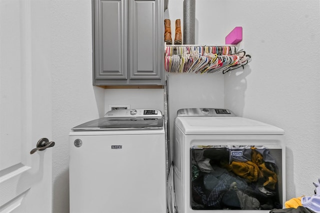 washroom featuring cabinets and independent washer and dryer