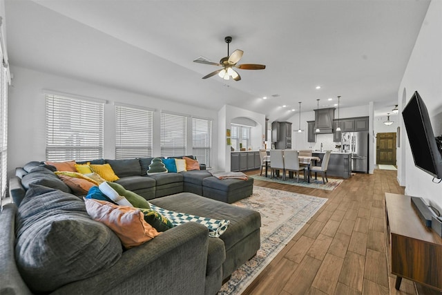 living room featuring hardwood / wood-style flooring, vaulted ceiling, and ceiling fan