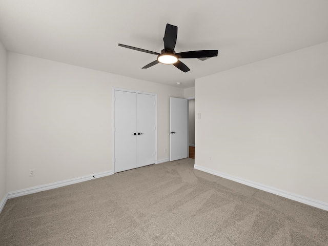 unfurnished bedroom with light colored carpet, a closet, and ceiling fan