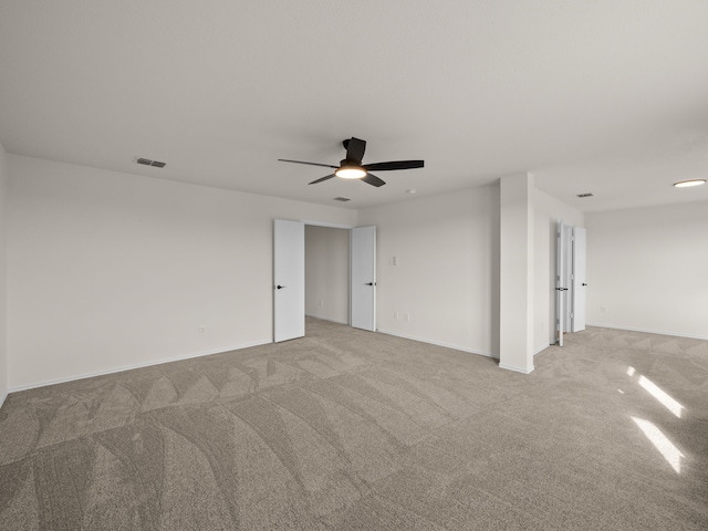 carpeted spare room featuring ceiling fan