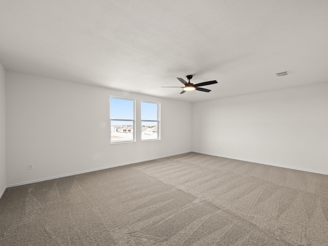 empty room featuring ceiling fan and light colored carpet