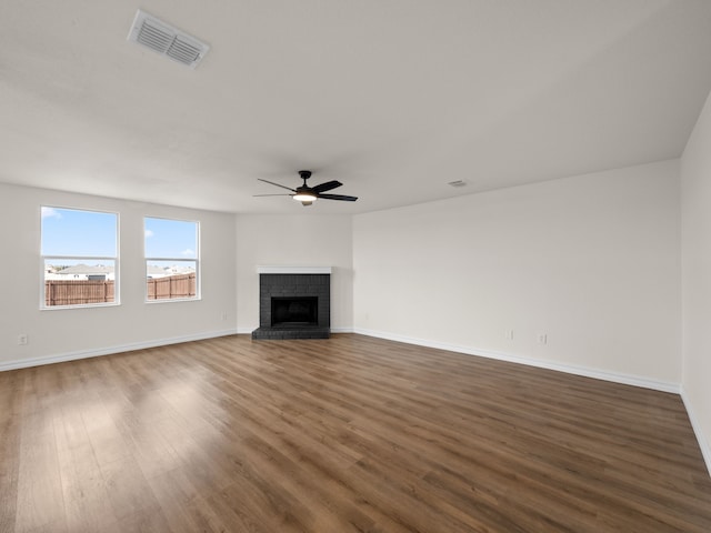 unfurnished living room with ceiling fan, dark wood-type flooring, and a fireplace