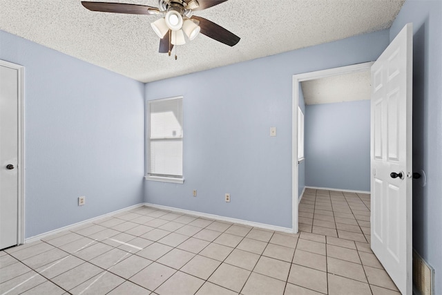 tiled spare room featuring a textured ceiling and ceiling fan