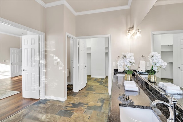 bathroom with hardwood / wood-style flooring, ornamental molding, vanity, and toilet