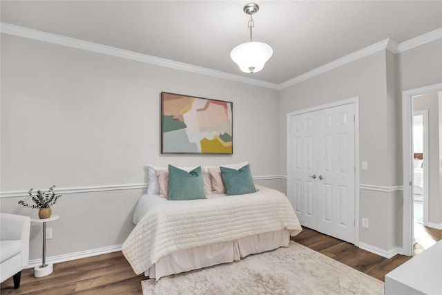 bedroom featuring ornamental molding, dark hardwood / wood-style flooring, and a closet