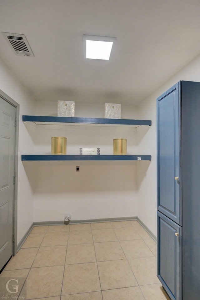 washroom with light tile patterned floors, baseboards, visible vents, and hookup for an electric dryer