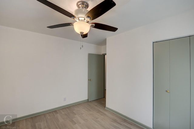 unfurnished bedroom featuring light wood finished floors, a closet, a ceiling fan, and baseboards