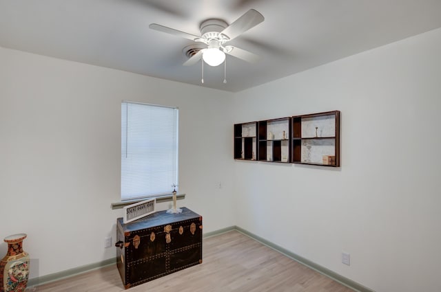 unfurnished room with light wood finished floors, ceiling fan, and baseboards