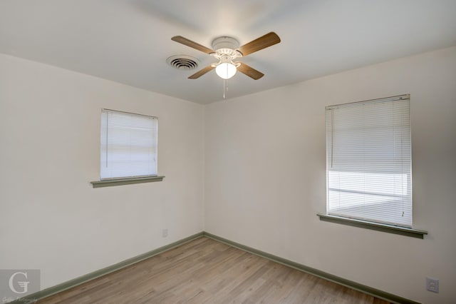 unfurnished room featuring ceiling fan, light wood-type flooring, visible vents, and baseboards