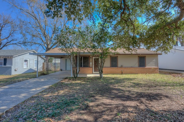 ranch-style home featuring concrete driveway, a front lawn, a carport, and brick siding