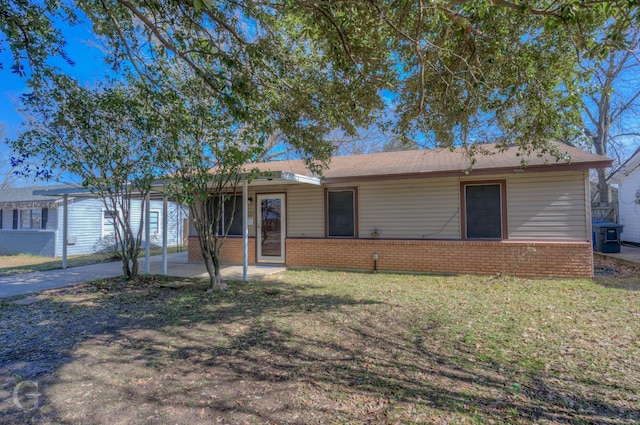 single story home with a carport, a front yard, a patio area, and brick siding