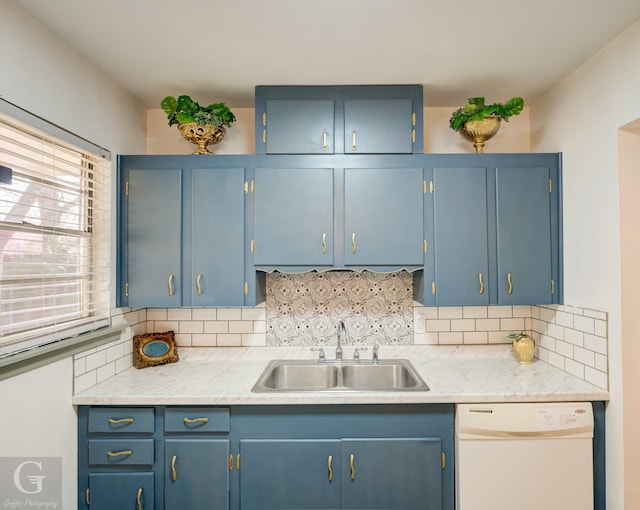 kitchen featuring tasteful backsplash, blue cabinets, dishwasher, and sink