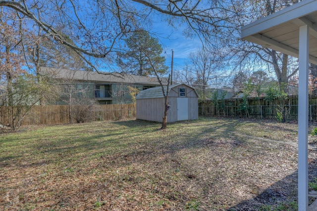 view of yard featuring an outbuilding, a storage unit, and a fenced backyard