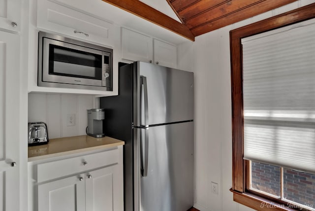 kitchen with white cabinetry, lofted ceiling, and appliances with stainless steel finishes