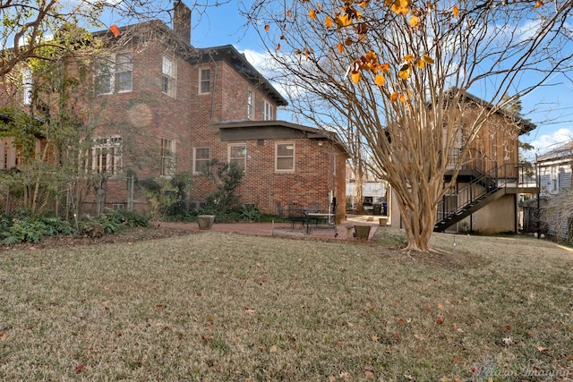 rear view of house featuring a yard and a patio area