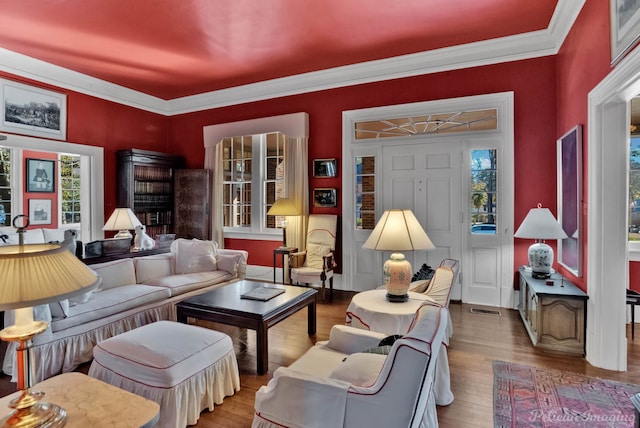 living room with hardwood / wood-style floors, plenty of natural light, and ornamental molding