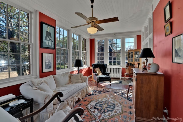 sunroom featuring ceiling fan, radiator, and wood ceiling