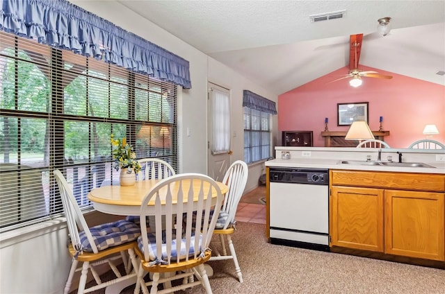 kitchen featuring lofted ceiling, sink, ceiling fan, white dishwasher, and light colored carpet