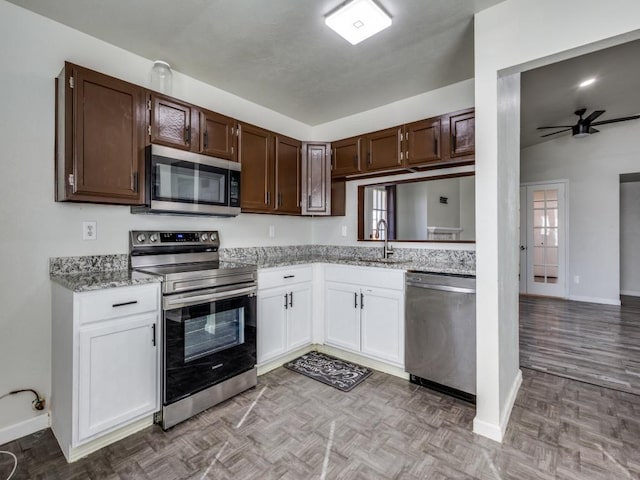 kitchen with sink, white cabinetry, appliances with stainless steel finishes, ceiling fan, and light parquet floors