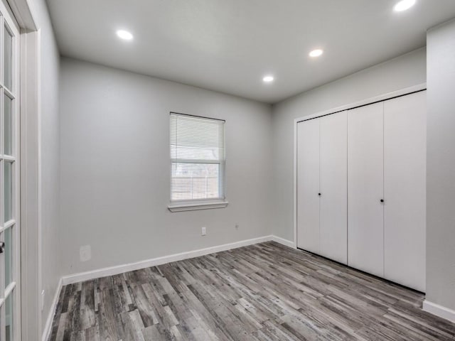 unfurnished bedroom with light hardwood / wood-style flooring and a closet